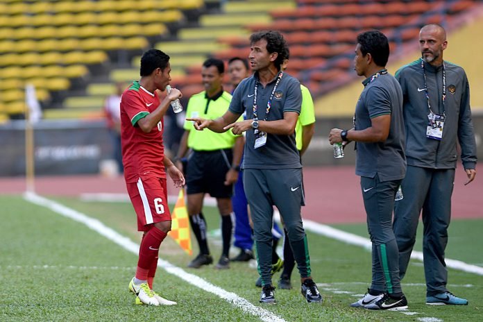 Pelatih Luis Mila (kedua kiri) memberi arahan kepada pemain Timnas U-22 Evan Dimas (kiri) saat melawan Timnas U-22 Kamboja pada laga terakhir penyisihan grup B SEA Games XXIX Kuala Lumpur di Stadion Shah Alam, Selangor, Malaysia, Kamis (24/8).