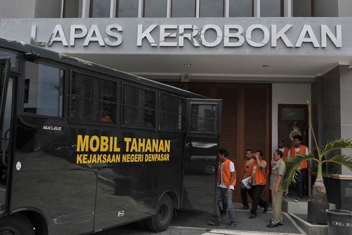 Petugas kejaksaan mengawasi para tahanan yang akan menjalani sidang pengadilan ketika mereka digiring melalui gerbang dan gedung baru Lembaga Pemasyarakatan (Lapas) Kerobokan, Denpasar, Selasa (24/2).