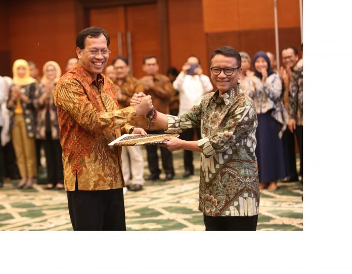 Direktur Jenderal Pajak Kementerian Keuangan yang baru Robert Pakpahan (kiri) berjabat tangan dengan pejabat lama Ken Dwijugiasteadi saat serah terima jabatan di kantor Kementerian Keuangan (Kemenkeu), Jakarta, Kamis (30/11).