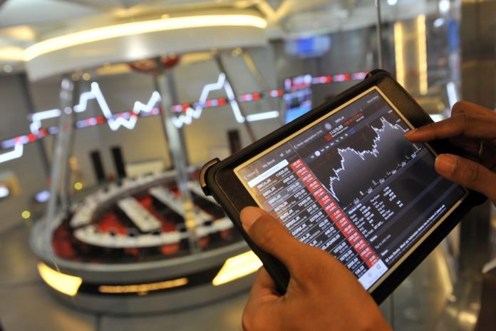 Seorang jurnalis mengamati pergerakan Indeks Harga Saham Gabungan (IHSG) di Bursa Efek Indonesia, Jakarta,