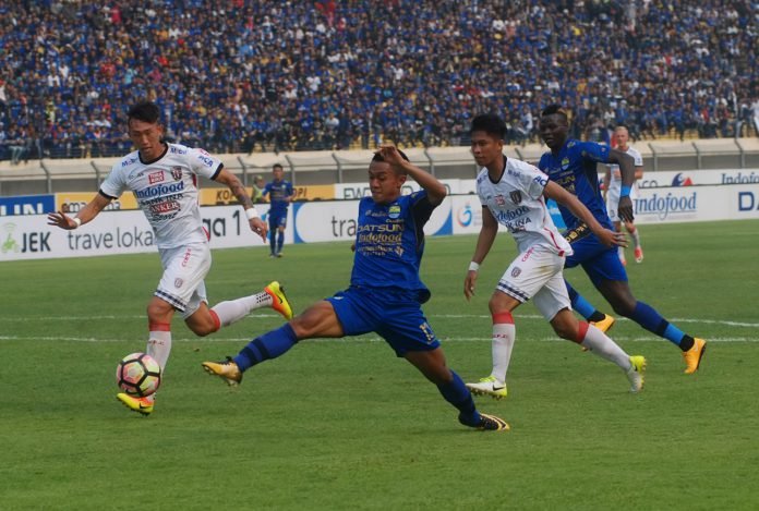 Pesepak bola Persib Bandung Febri Hariyadi (kedua kiri) menendang bola dengan kawalan dua pesepak bola Bali United pada laga lanjutan GO-JEK Traveloka Liga 1 di Stadion Si Jalak Harupat Soreang, Kabupaten Bandung, Jawa Barat, Kamis (21/9).