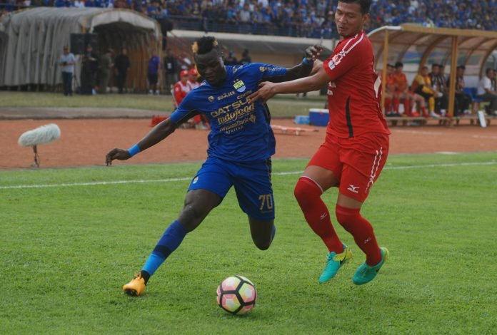 Pesepak bola Persib Bandung Ezechiel Ndouasel (kiri) berebut bola dengan pesepak bola Semen Padang FC Agung Prasetyo (kanan) pada laga lanjutan GO-JEK Traveloka Liga 1 di Stadion Si Jalak Harupat Soreang, Kabupaten Bandung