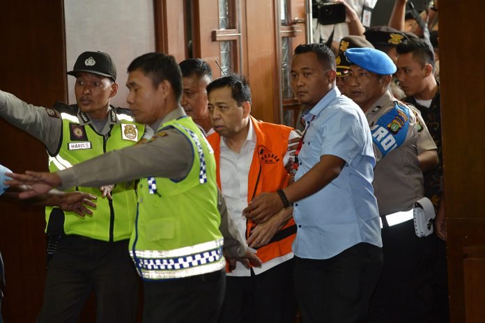 Terdakwa kasus dugaan korupsi KTP elektronik Setya Novanto (tengah) memasuki ruangan pada sidang perdana di gedung Pengadilan Tipikor Jakarta, Rabu (13/12).
