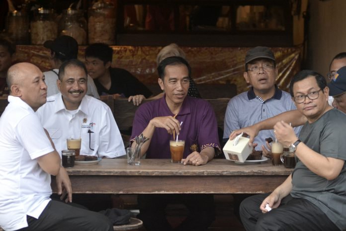 Presiden Joko Widodo bersama Menpar Arief Yahya (kedua kiri), Mensesneg Pratikno (kedua kanan), Seskab Pramono Anung (kanan) dan Kepala Staf Kepresidenan Teten Masduki (kiri) bersantai saat mengunjungi kawasan wisata Kuta, Bali, Jumat (22/12).